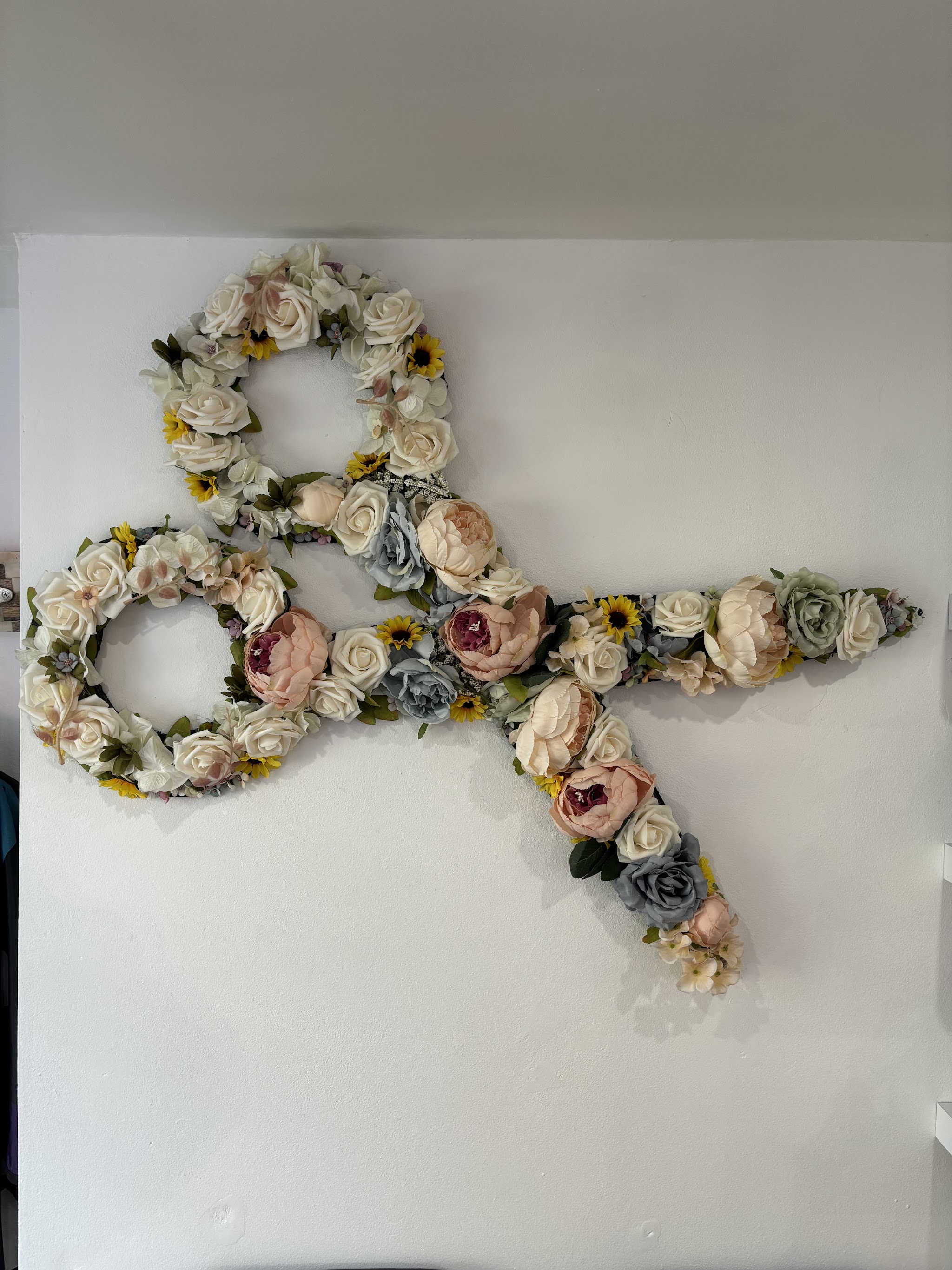 Giant scissors made of flowers on the salon wall