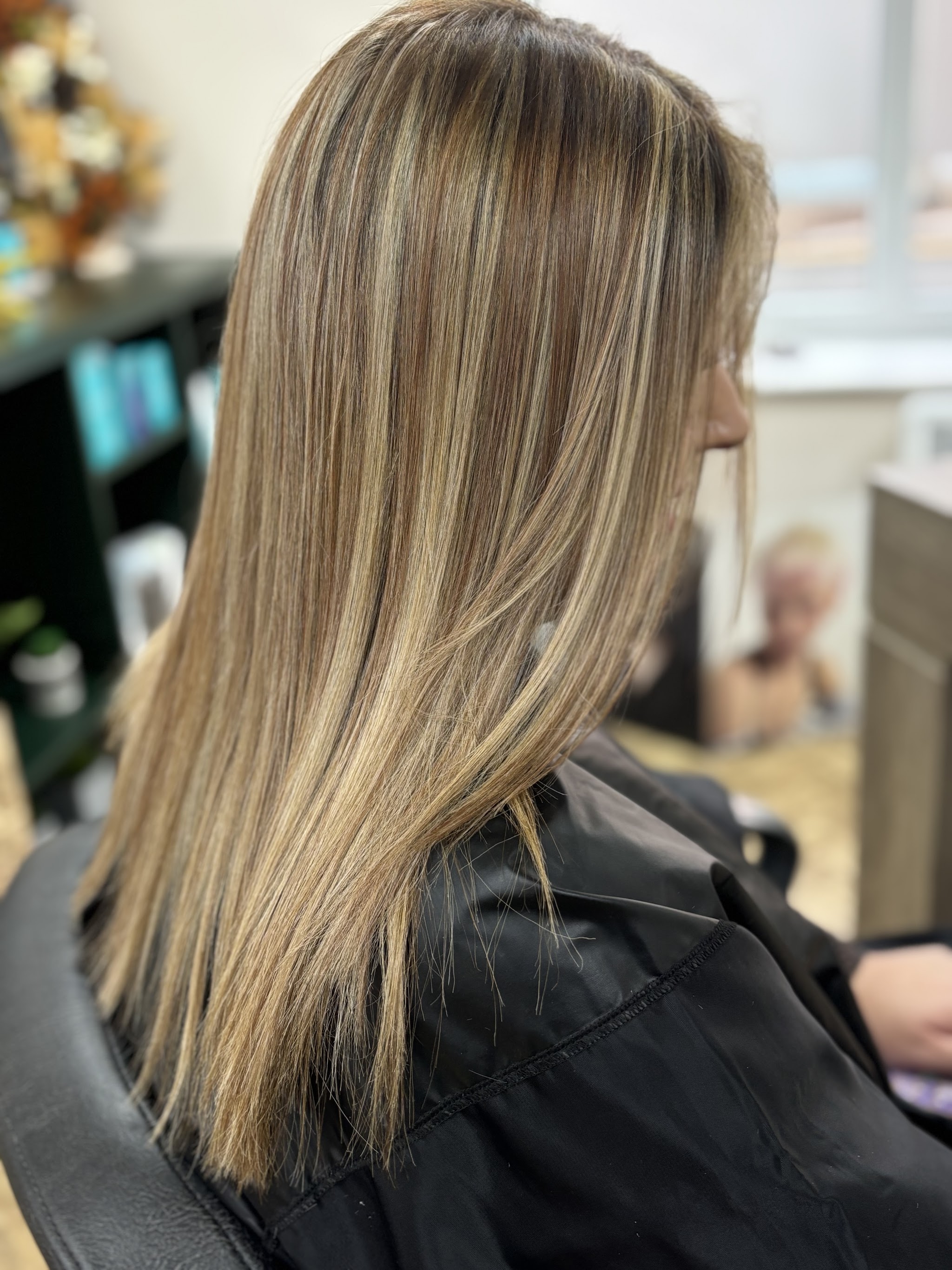 Long blonde balayage with highlights, client in the salon chair