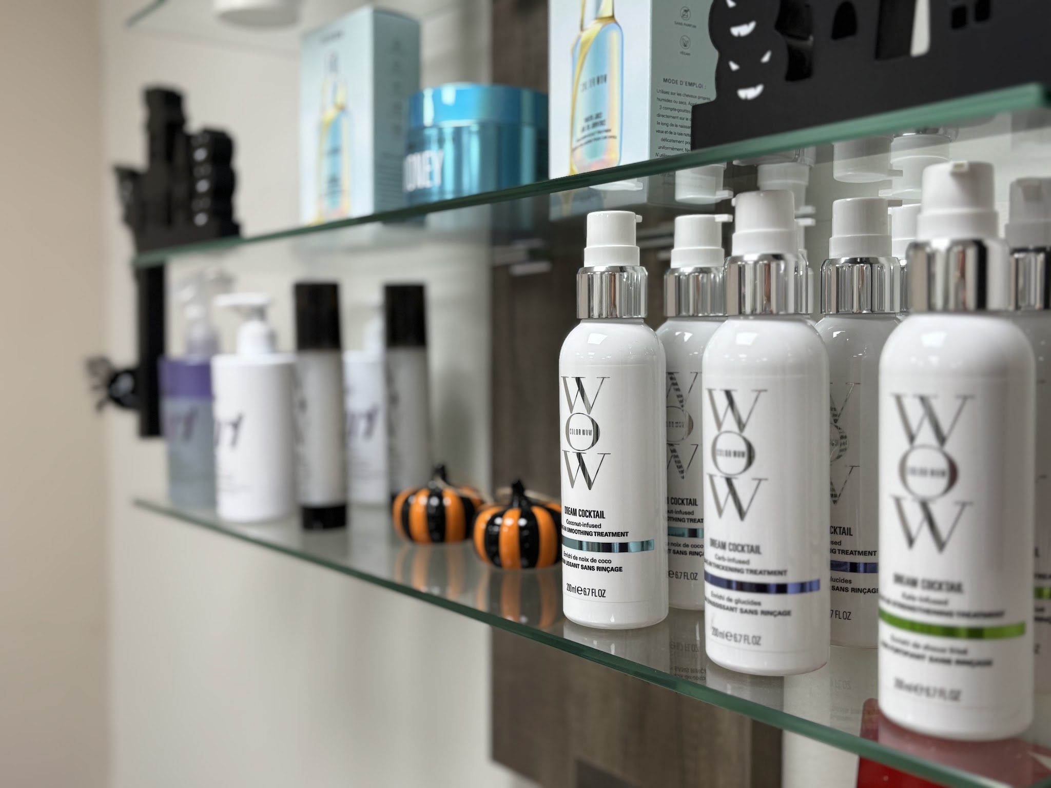 Hair products lined up on a glass shelf