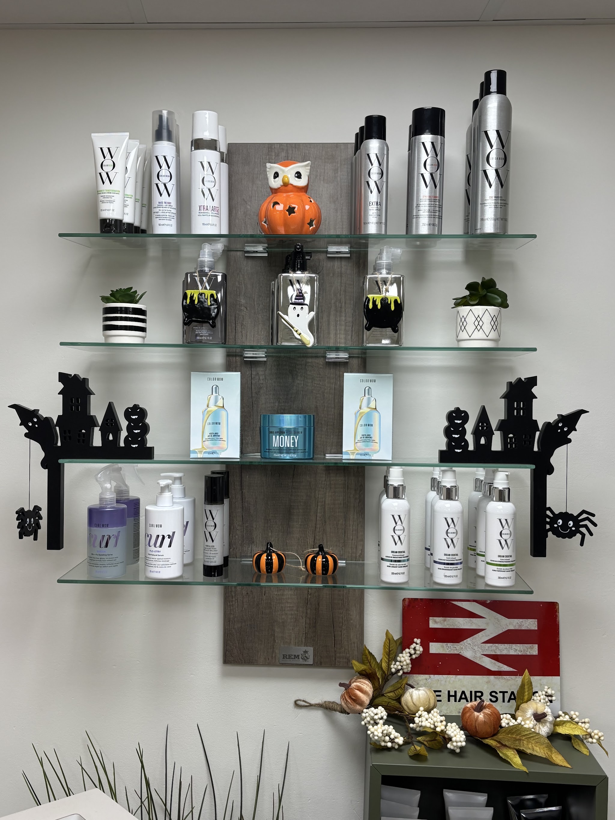 Glass shelves of hair products above The Hair Station railway sign